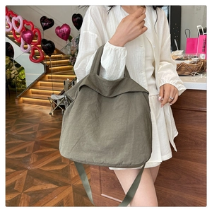 Gros plan d'un grand sac fourre-tout en nylon vert olive avec bandoulière large