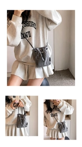 Detailed view of dark grey nylon mini drawstring bag with adjustable shoulder strap
