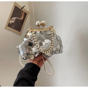 Close-up of silver sequin evening bag with large pearl clasp and bead chain strap