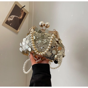 Detail of luxury sequined evening bag with pearl top handle and metal clasp closure