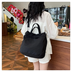 Détail d'un sac bandoulière en nylon noir avec sangle réglable dans un café élégant
