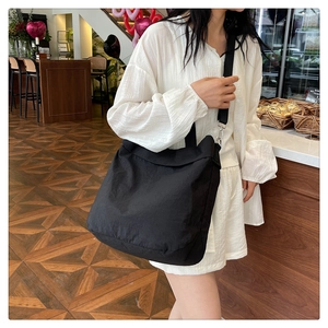 Détail de la bandoulière noire réglable et de la boucle en métal sur le grand sac en nylon