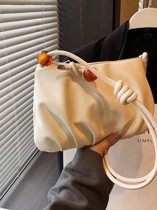 Elegante bolso nube plisado beige con asa anudada y detalles de cuentas ámbar