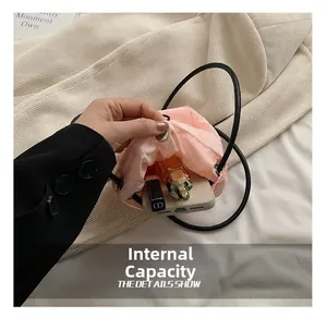 Detailed interior of a pink nylon mini drawstring bag showing phone and lipstick storage