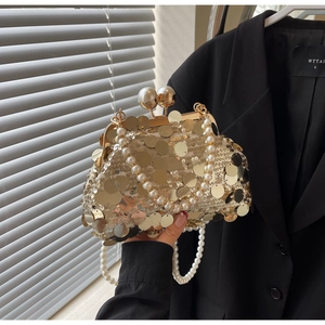 Detail of gold sequin evening bag featuring pearl handle and double pearl clasp closure