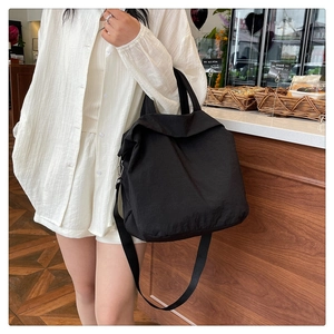 Photo de style d'un grand sac cabas noir avec bandoulière réglable et poignées robustes