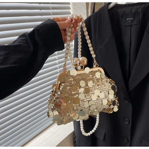 Detail of gold sequin evening bag with double pearl handles and spherical pearl clasp