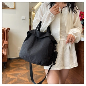 Détail du fourre-tout en nylon noir avec bandoulière réglable et ferrures métalliques