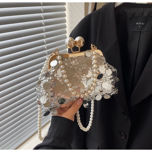 Detailed close-up of a silver sequin evening bag with pearls and vintage gold metal clasp