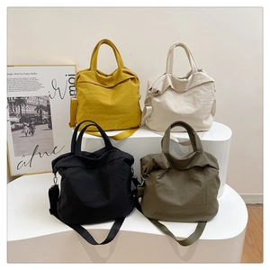 Vue détaillée de grands sacs fourre-tout en nylon en quatre couleurs sur un présentoir