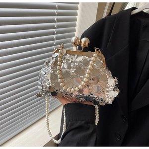 Close-up of silver sequin evening bag featuring large pearl clasp and pearl chain strap