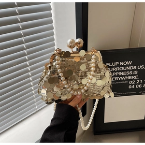 Detailed view of luxury gold sequin evening bag with elegant pearl chain and handle