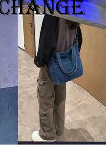 Dettaglio della borsa tote in denim blu con tasche funzionali e stile a tracolla