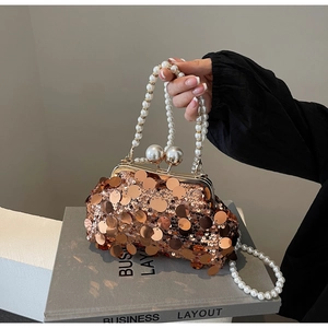 Close-up of bronze sequins, pearl strap, and dual pearl clasp on luxury evening clutch