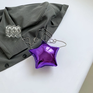 Vue détaillée du mini sac étoile en acrylique violet avec chaîne argentée sur veste