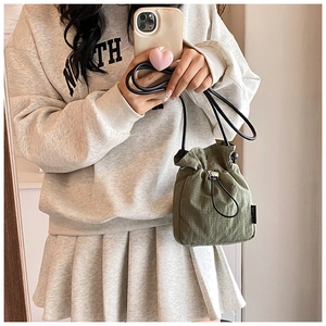 Detail view of army green mini drawstring nylon bucket bag with adjustable cord strap