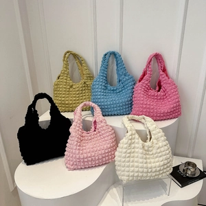 Kollektion bunter Handtaschen mit Popcorn-Textur in Gelb Blau Rosa und Weißtönen