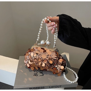 Detail of rose gold sequins evening bag with pearl handle and metal sphere clasp