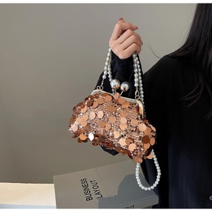 Close-up of champagne sequin evening bag with pearl handle and metal clasp