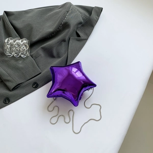 Détail du mini sac violet en forme d'étoile avec une bandoulière chaîne argentée