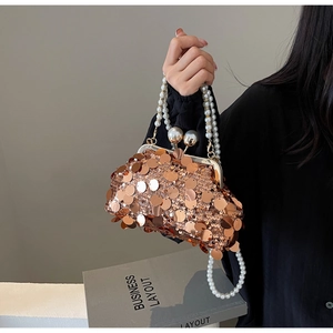 Detail of rose gold sequin evening bag featuring a pearl handle and pearl chain strap