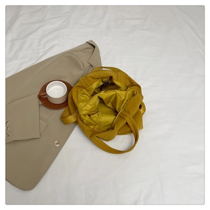Vue détaillée de l'intérieur du fourre-tout en nylon jaune moutarde avec boucle