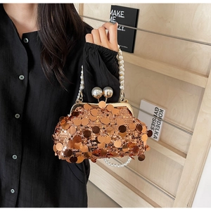 Detailed macro view of sequin clutch bag featuring pearl handle and metallic frame closure