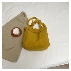 Gros plan d'un sac cabas en nylon jaune moutarde avec bandoulière en cadre décontracté