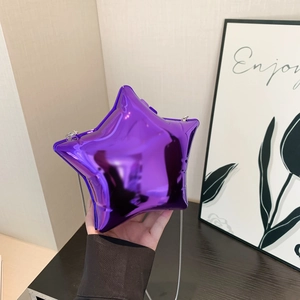 Détail d'un petit sac bandoulière violet en forme d'étoile avec une finition métallique