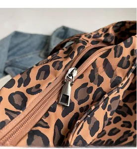 Detailed macro view showing the smooth silver metal zipper on leopard print tote bag