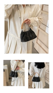 Détail du sac froissé noir avec poignée en bois et bandoulière en perles blanches