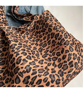 Close-up of leopard print tote bag fabric texture with soft canvas and denim jacket