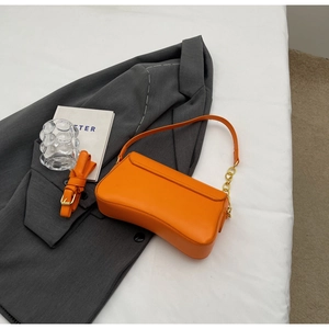 Bovenaanzicht van feloranje PU-lederen baguettetas met gouden ketting en riemdetails