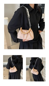 Détail du sac seau plissé rose avec poignée en bois et bandoulière en perles blanches