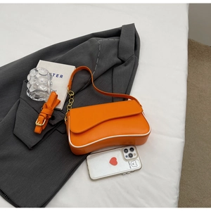 Detailweergave van stijlvolle oranje onderarmtas met witte bies en gouden ketting