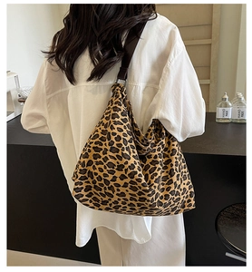 Detailed view of the large leopard print hobo bag worn on the shoulder in a lifestyle setting