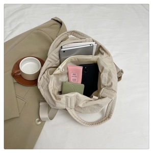 Vue de haut du sac cabas beige en nylon matelassé avec grand intérieur et bandoulière