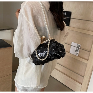 Close-up of black sequin evening bag featuring large pearl clasp and pearl beaded strap