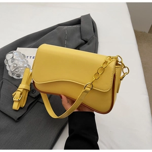 Detail van gele PU-leren tas met golfvormige flap, gouden ketting en verstelbare riem