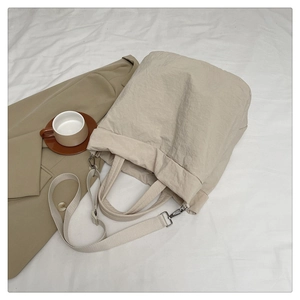 Vue détaillée du sac en nylon beige minimaliste et des accessoires métalliques