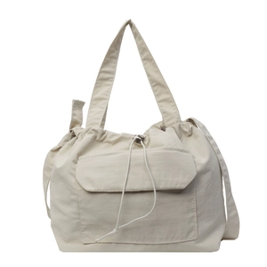 Sac fourre-tout en nylon beige avec cordon de serrage et grande poche avant sur fond blanc