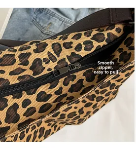 Close-up of the smooth black nylon zipper and metal hardware on the leopard print canvas bag