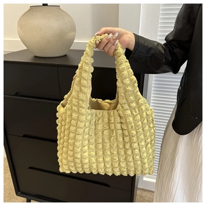 Detail der hellgelben Popcorn-Struktur-Tasche mit einzigartigen 3D-Stofffalten-Effekt