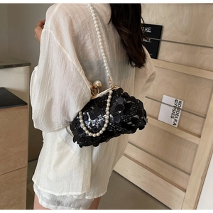 Detail of black sequined evening bag with large pearl clasp and pearl chain strap