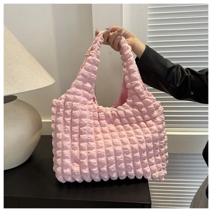Detail der rosa Bubble-Textur an einer modischen Puffer-Tragetasche für Damen