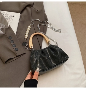 Détail du sac seau noir plissé avec poignée en bois et bandoulière en perles
