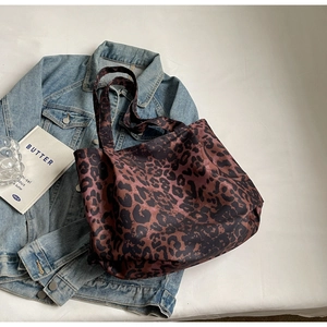 Detail view of large leopard print tote bag with thick handles on stylish setup