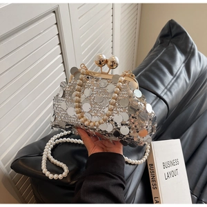 Detail of silver sequin clutch bag with dual pearl handle and elegant metal clasp