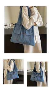 Detail of blue denim tote bag featuring utility pockets and contrast stitching accents