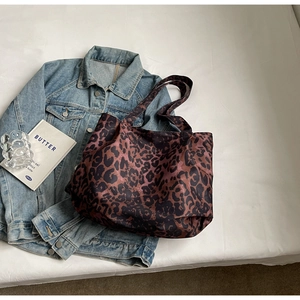 Close-up of leopard print tote bag on denim jacket with a minimalist large capacity design